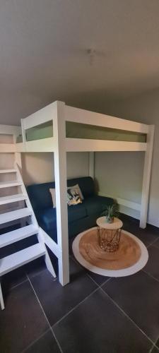 a room with a bunk bed and a couch at Les Gîtes Kajou in Bouillante