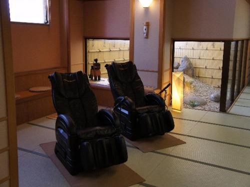 two black chairs in a room with a mirror at Hotel Shirakawa Yunokura in Nikko