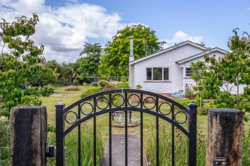 a gate in front of a white house at Greytown Farmhouse in Greytown