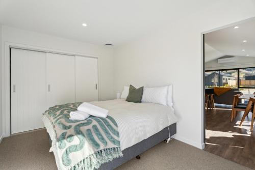 a bedroom with a bed and a sliding glass door at Wooing Tree Beauty - Cromwell Holiday Home in Cromwell
