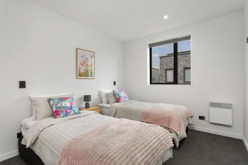 Un dormitorio con dos camas y una ventana. en Spring Special CBD Free Parking, en Christchurch