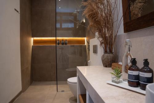 a bathroom with a toilet and a glass shower at Flora Villa Priv Pool By Yemaya in Kuta Lombok