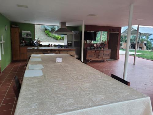 a long table in a room with a kitchen at Finca Familiar Talena in Sopetran