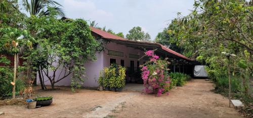 a house with pink flowers in front of it at The Purple House in Siem Reap