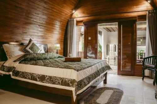een slaapkamer met een bed en een houten wand bij Kubu Silvia in Nusa Dua