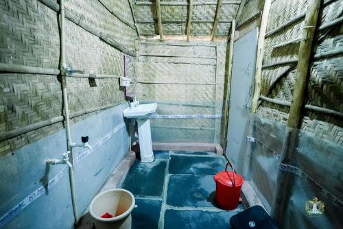 a small bathroom with a sink and a toilet at Hampi Waterfall Cottages in Hampi