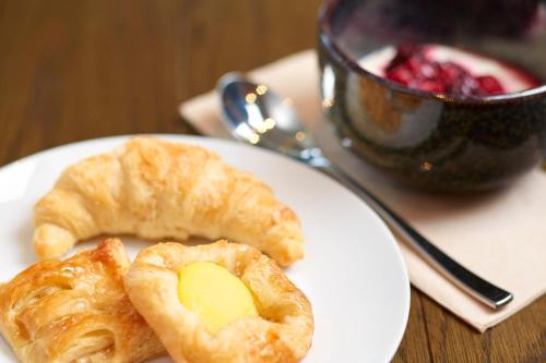 a white plate with pastries on a table with a cup at Holiday Inn Express Adelaide City Centre by IHG in Adelaide