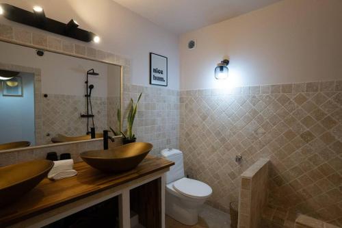 a bathroom with two sinks and a toilet at Condo Flamingo with pool in Baie Nettle