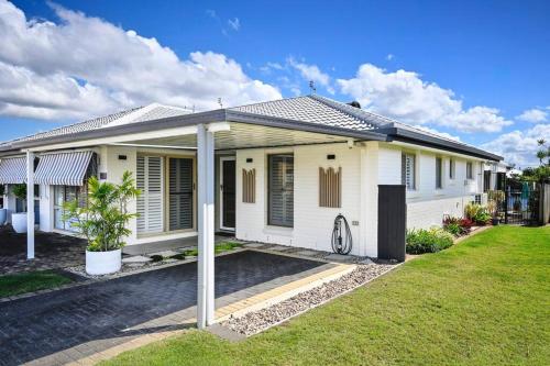 a white house with a lawn in front of it at Waterfront Stylish Luxury, Light, Relaxed in Parrearra
