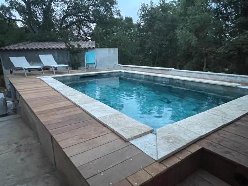 une piscine avec une terrasse en bois et une piscine dans l'établissement Les oliviers de Murateddu (Maison individuelle), à Porto-Vecchio