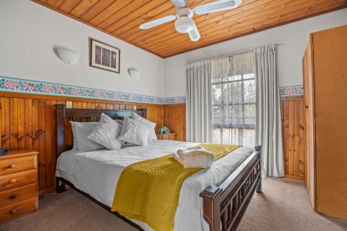 una camera da letto con un letto e un ventilatore a soffitto di StayAU Lakeview Cottage 2BR Cozy Nature Getaway a Badger Creek