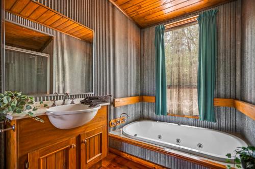 un bagno con vasca e lavandino di StayAU Lakeview Cottage 2BR Cozy Nature Getaway a Badger Creek