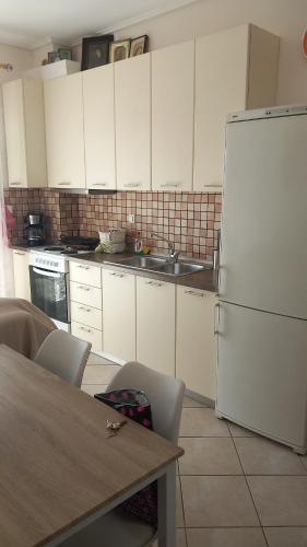 a kitchen with white cabinets and a white refrigerator at Sofia's Apartment in Kavala