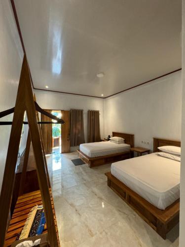 a bedroom with two beds and a staircase at Sunari Beach Resort 2 in Selayar