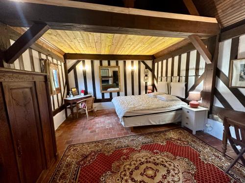 une chambre avec un lit et un bureau dans une pièce dans l'établissement La Soulterie, à Crouttes