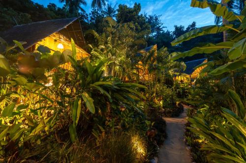 a path through a garden at night at Bamboo Bay Eco Resort in Srithanu