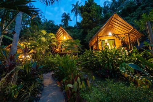 a resort in the jungle at night with lights at Bamboo Bay Eco Resort in Srithanu