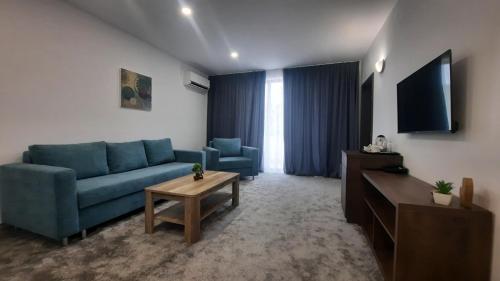 a living room with a blue couch and a tv at Хотел Релакс in Kazanlŭk