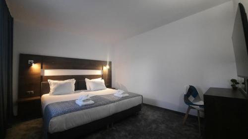 a bedroom with a bed with two towels on it at Хотел Релакс in Kazanlŭk