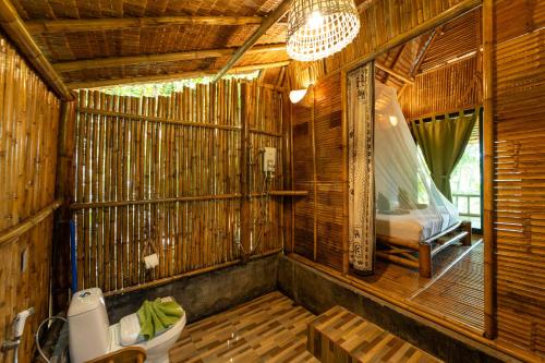 a bathroom with a toilet in a bamboo house at Bamboo Bay Eco Resort in Srithanu