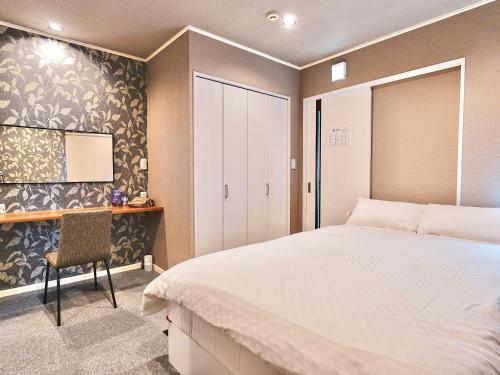 une chambre avec un grand lit et une chaise dans l'établissement F House 青い海, à Osaka