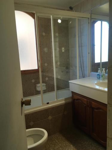 a bathroom with a toilet and a shower and a sink at Depto Agua Marina vista al mar in La Serena
