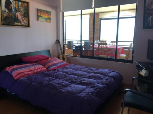 a bedroom with a bed with a blue comforter at Depto Agua Marina vista al mar in La Serena