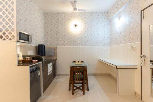 a small kitchen with a counter and a table at Bauhinia in Pune