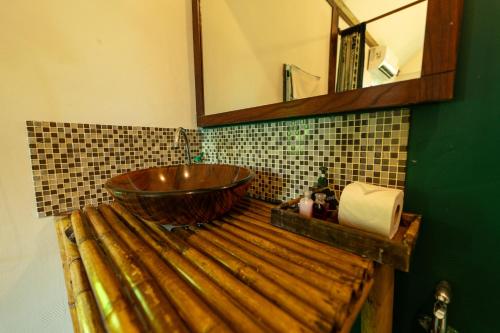 a bathroom with a wooden sink and a mirror at Bamboo Bay Eco Resort in Srithanu
