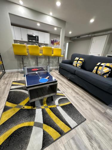 a living room with a blue couch and yellow chairs at Games Haven with Crib Mins from AT&T, Sixflags, UTA, GlobeLife, AmericanAirlinesCenter in Arlington