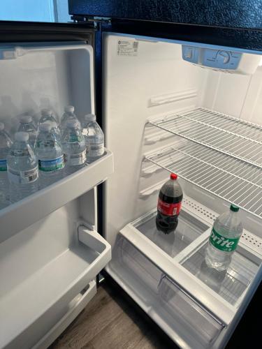 an open refrigerator with bottles of water in it at Games Haven with Crib Mins from AT&T, Sixflags, UTA, GlobeLife, AmericanAirlinesCenter in Arlington