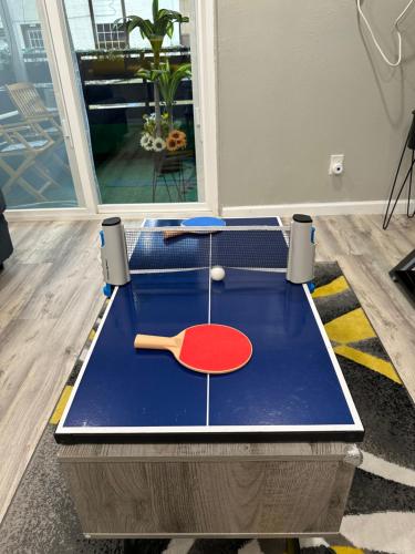 a ping pong table with a racket and ball on it at Games Haven with Crib Mins from AT&T, Sixflags, UTA, GlobeLife, AmericanAirlinesCenter in Arlington