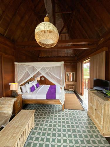 a bedroom with a bed and a television in it at Uma Sebatu Villa Ubud in Tegalalang