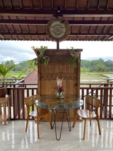 a table and chairs on a deck with a view at Uma Sebatu Villa Ubud in Tegalalang