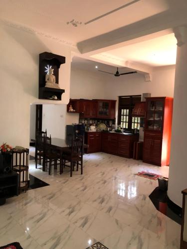 a large kitchen with a table and a refrigerator at SRI LANKAN VILLA in Galle
