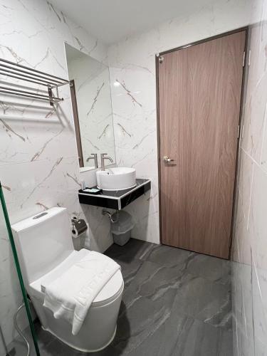 a bathroom with a toilet and a sink at เวลโกรว์ โฮเทล - Wellgrow Hotel in Ban Bang Kha