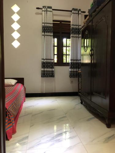 a living room with a bed and a window at SRI LANKAN VILLA in Galle