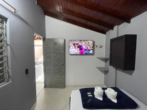 a room with a tv and towels on a bed at Hotel Las Vegas in Guatapé