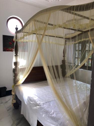 a bedroom with a bed with a canopy at SRI LANKAN VILLA in Galle