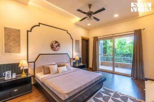 a bedroom with a bed with a ceiling fan at StayVista at Wandering Vines 4BHK with FREE Breakfast ,Indoor Pool in Delhi Sohna in Sohna