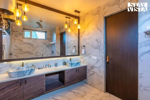 a bathroom with two sinks and a large mirror at StayVista at Wandering Vines 4BHK with FREE Breakfast ,Indoor Pool in Delhi Sohna in Sohna