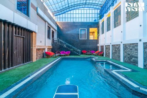 a person in a swimming pool in a building at StayVista at Wandering Vines 4BHK with FREE Breakfast ,Indoor Pool in Delhi Sohna in Sohna
