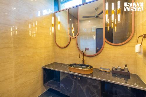 a bathroom with a sink and a mirror at StayVista at Wandering Vines 4BHK with FREE Breakfast ,Indoor Pool in Delhi Sohna in Sohna