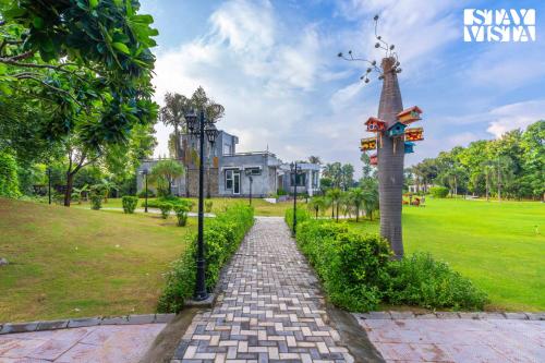 a brick path in a park with a pole at StayVista at Wandering Vines 4BHK with FREE Breakfast ,Indoor Pool in Delhi Sohna in Sohna