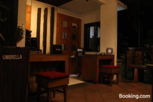 a room with a bar with chairs and a table at Sarinande Hotel in Seminyak
