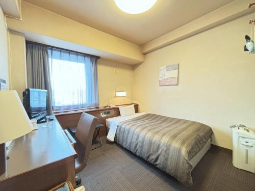 a hotel room with a bed and a desk with a computer at Hotel Route-Inn Ueda -Kokudou 18 Gou- in Ueda