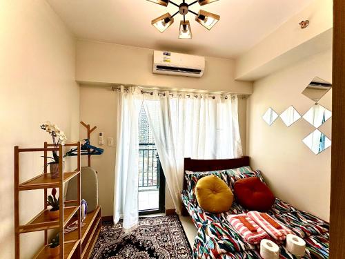 a living room with a couch and a window at High Rise Condo with Balcony, Pool, Grand Lobby,Gym and Sky Garden 22F in Manila