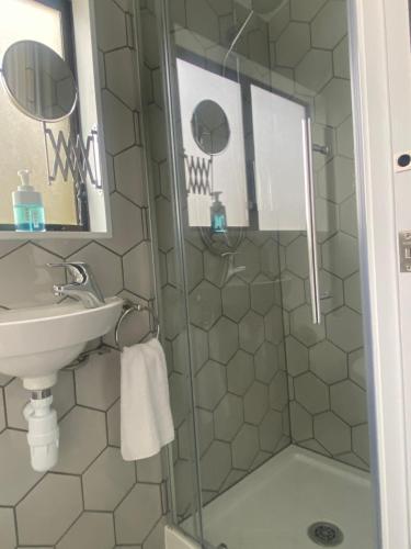 a bathroom with a sink and a shower at Christchurch Airport Tiny House in Christchurch