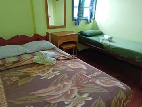 a bedroom with two beds and a mirror and a bed with flowers at Las vegas lodge and restaurant in Banaue