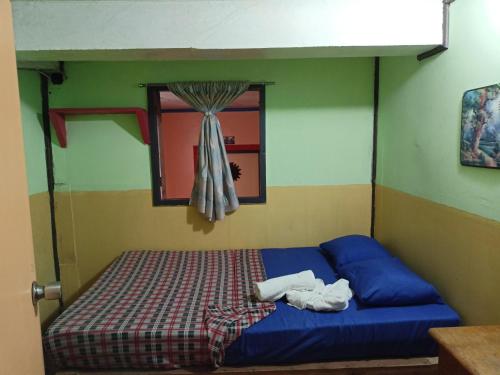 a bed in a room with a window at Las vegas lodge and restaurant in Banaue